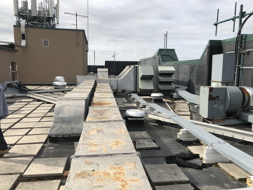 Flat Roof Cluttered with lots of equipment | getflatroofing.com