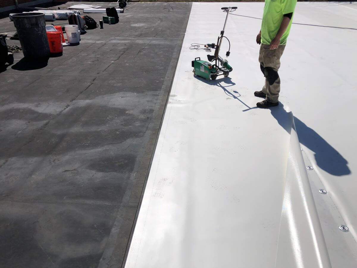 Worker Installing Flat Roof | getflatroofing.com 