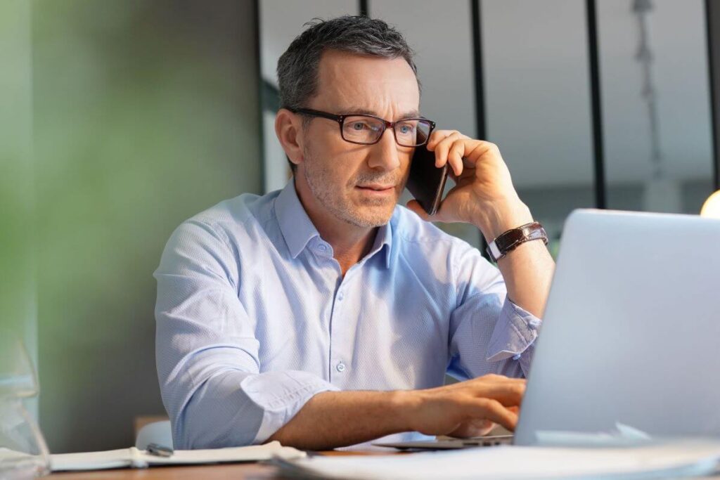 Building owner on phone and computer 